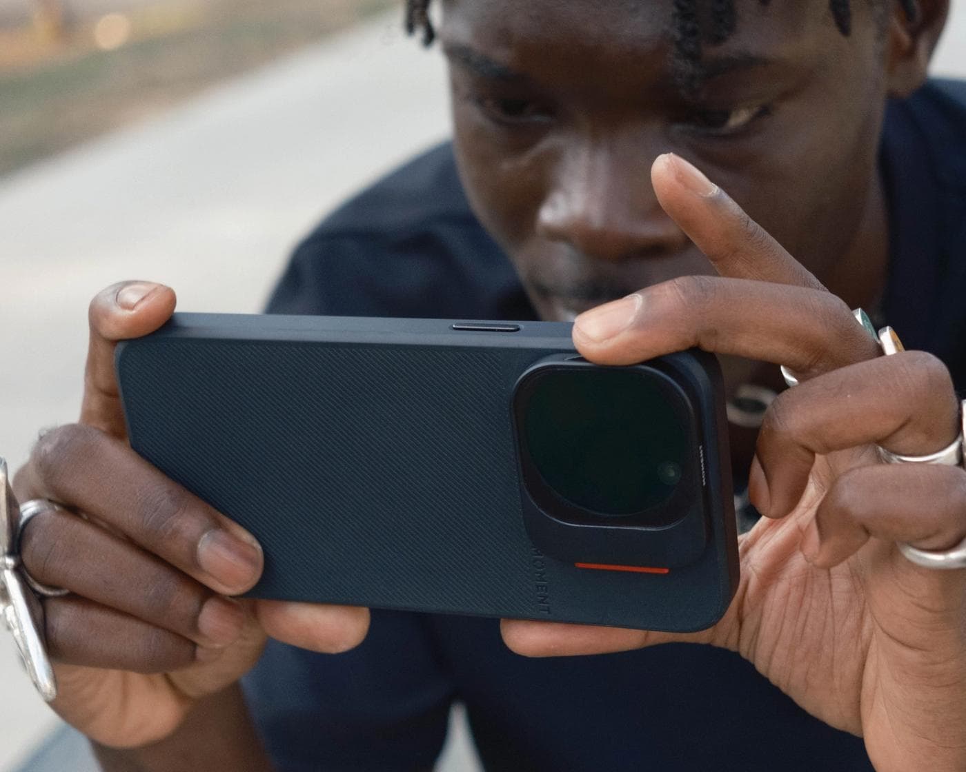 Creator using the iPhone 16 with a camera case in blue and QuickLock filters.