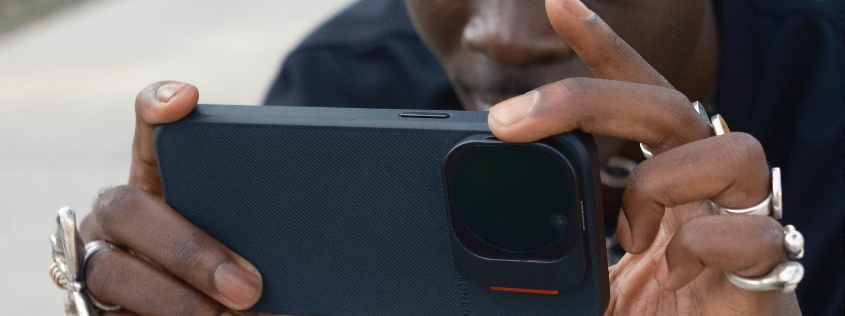 Creator using the iPhone 16 with a camera case in blue and QuickLock filters.